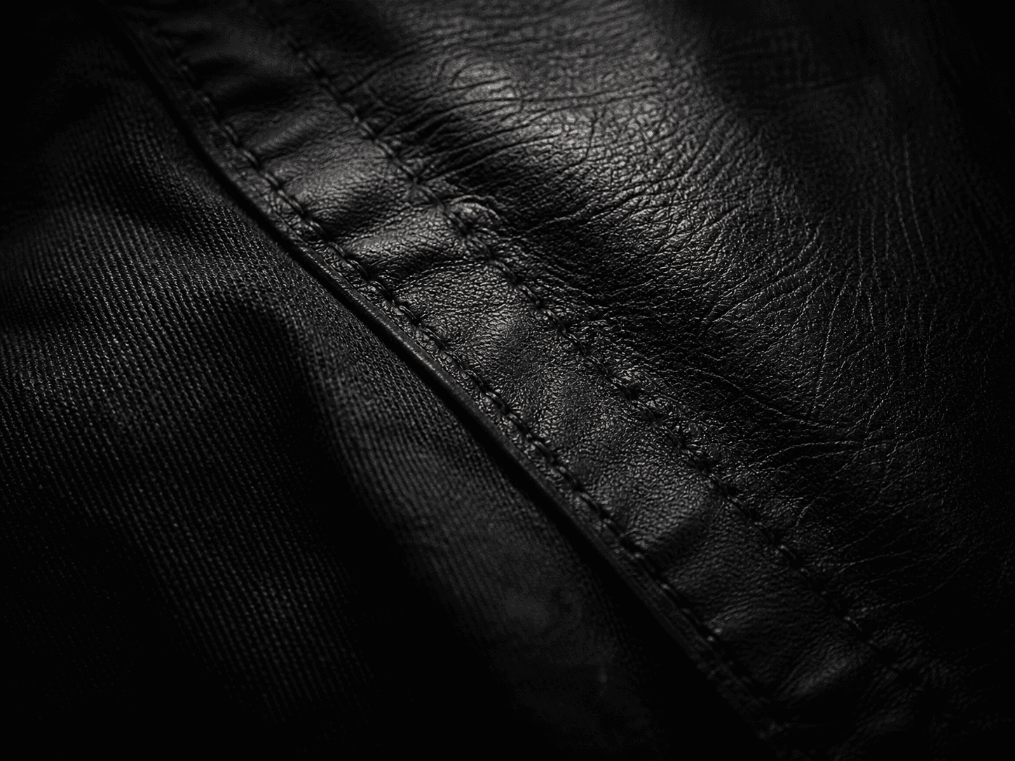 Close-up of stitched leather and heavy denim seam
